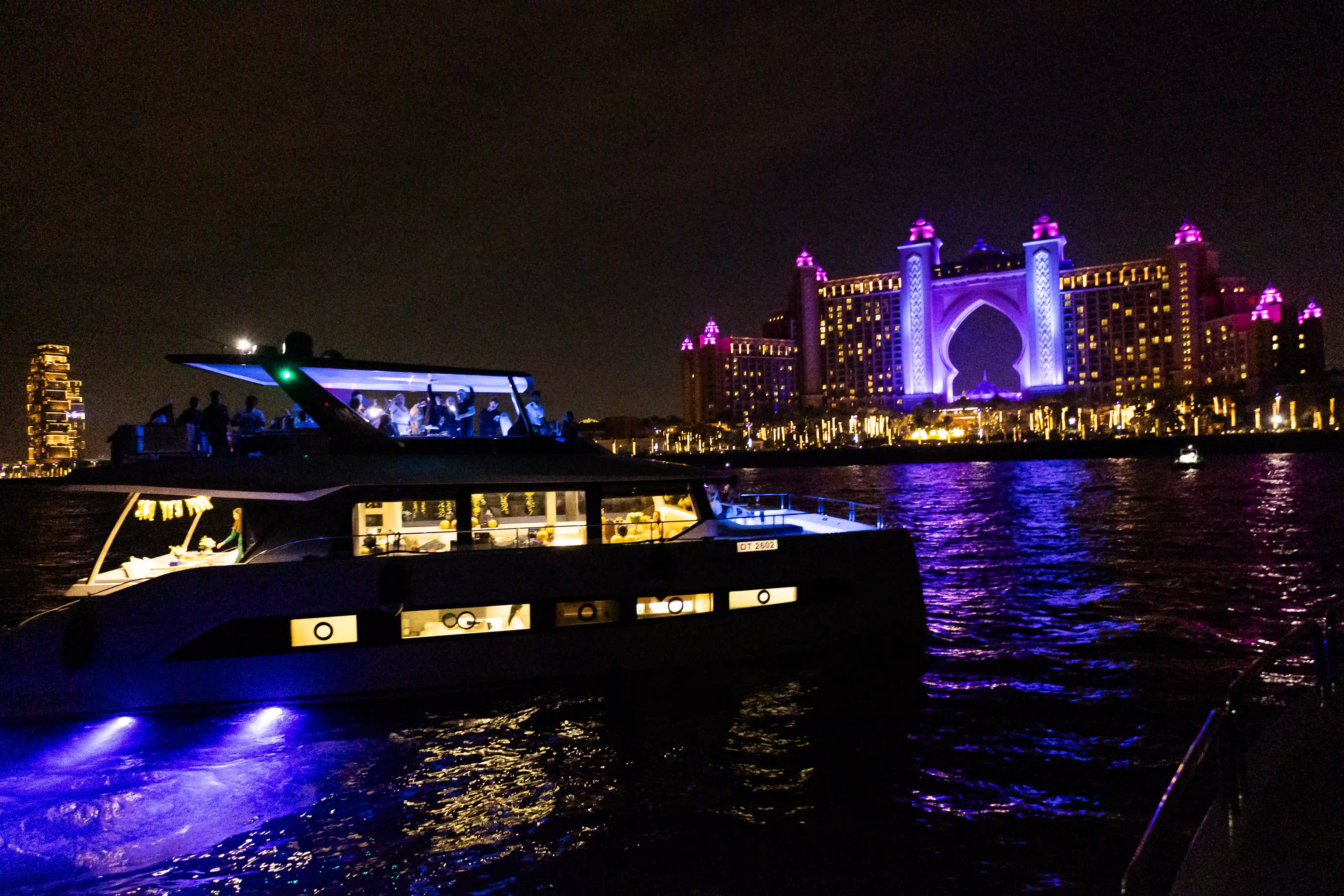 Luxury yacht sailing near Atlantis The Palm at night during Dubai New Year’s Eve