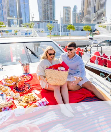 A couple celebrating their wedding anniversary sitting on the foredeck of a chartered yacht